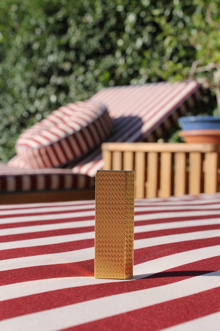 Cartier gold lighter with woven engraving standing upright