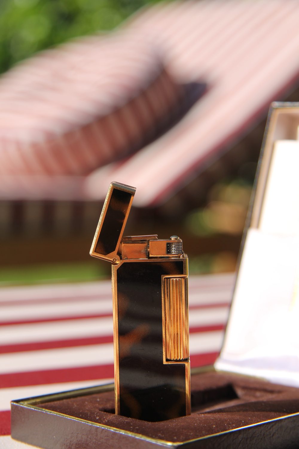 Dunhill Rollagas tortoiseshell lighter with the lid open, standing in its brown box